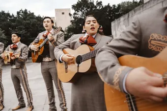 A line of guitar players perform during an outdoor Mariachi concert