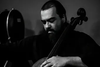 A black and white photo of a man playing a string instrument.
