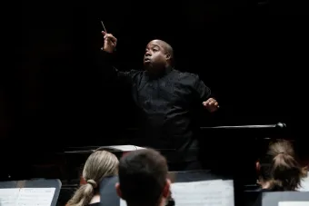 Clifford Croomes conducts from the podium in Bates Recital Hall