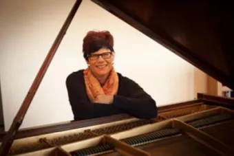 Lucia Unrau sits at a piano