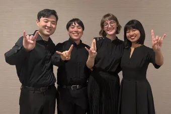 Soha, quartet composed of Mei Liu (violin), Chloe Yofan (violin), Thomas Gougeon (viola), and Katusaki Arakawa (cello) showing the hook em sign