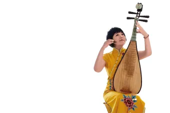 Gao Hong wearing a yellow dress playing her pipa