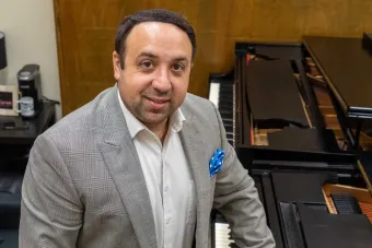 Ross Margitza standing in front of a piano