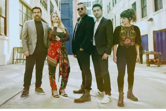 Members of Sybarite 5 casually posing on a street.