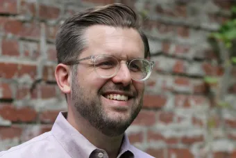 Robert Honstein smiling with a brick background