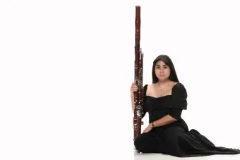 A headshot of Isabella Perez with her bassoon