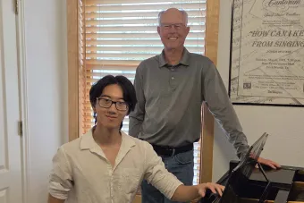 Jeffery Li and Charles Quereau stand in front of a piano