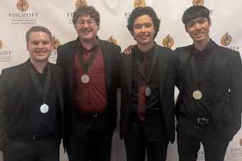 The members of 4116 Saxaphone quartet standing with medals around their neck