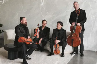 The Miro Quartet sit in a minimalist white room with their instruments
