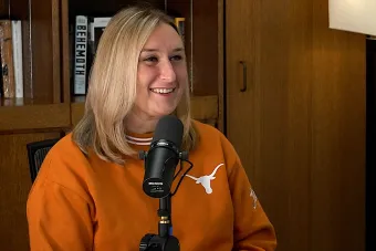 Marissa Guarriello talking into a mic with a bookshelf in the background