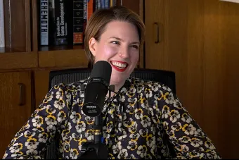 Page Stephens talking into a mic with a bookshelf in the background