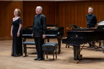 Musicians stand on stage and face the audience