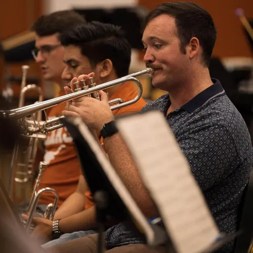 Headshot of Samuel Acosta playing trumpet in band