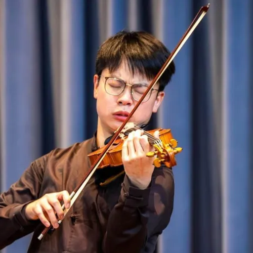 Zhengnan Eric Want plays his violin on stage