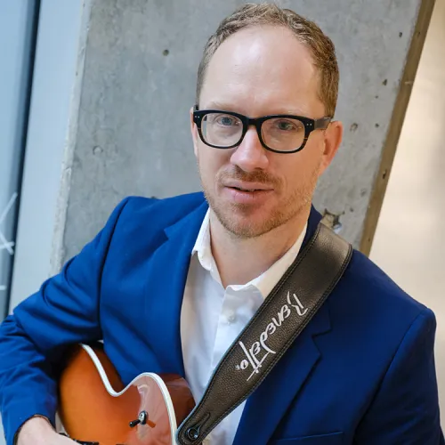 a headshot of Jacob Wise with his guitar