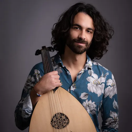 a headshot of Dimitris Gkoulimaris, holding an oud.