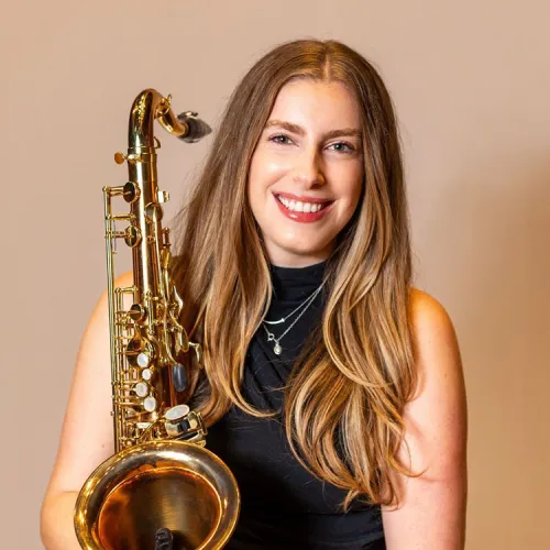 A headshot of Marina Sakellakis with her saxophone