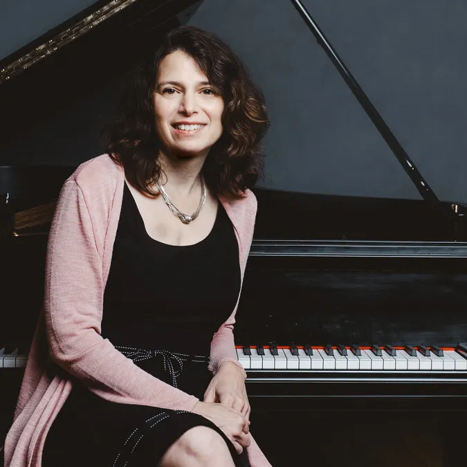 Pattie Wolf sits at a Piano