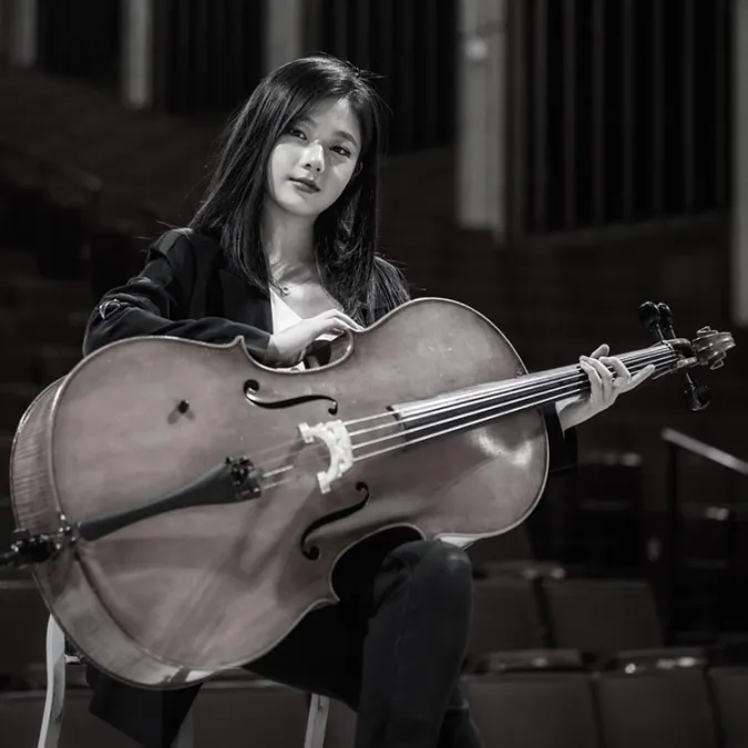 a headshot of Selina Xu with her cello.