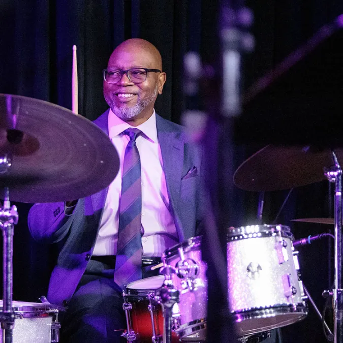 Nash Lewis plays the drum set during a live event.