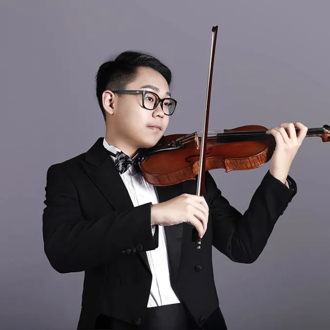 a headshot of Yuson Zhao playing his violin