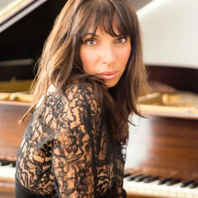 A headshot of Lara Downes ad the piano
