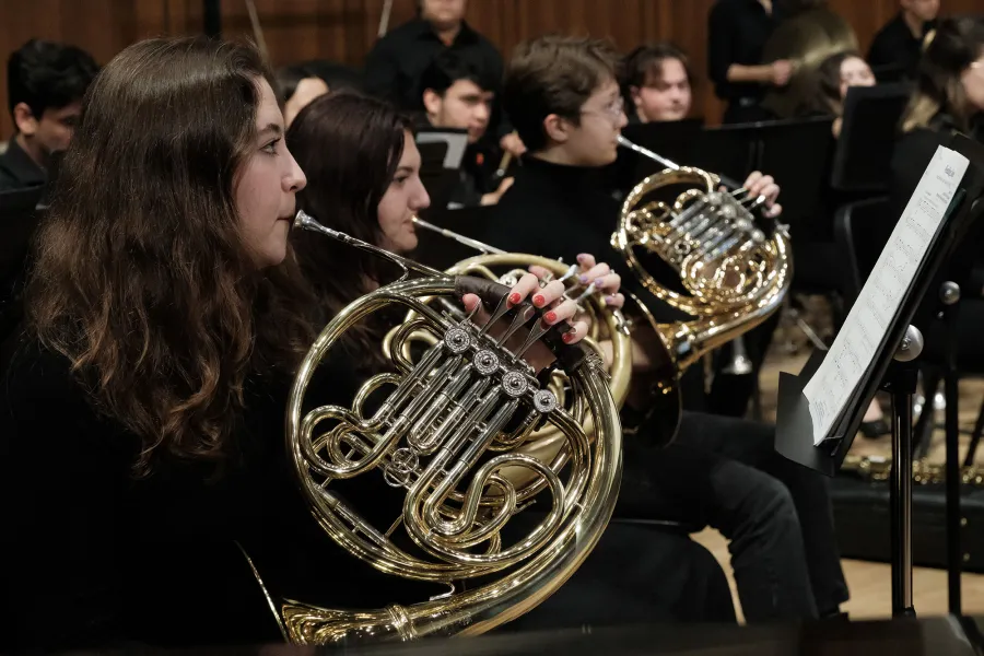 The horn section of Wind Symphony during a performance in Bates Recital Hall