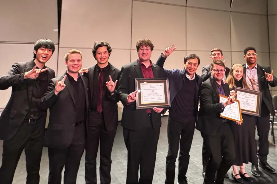 Members of the Zed and 4116 quartet standing on stage celebrating their victory