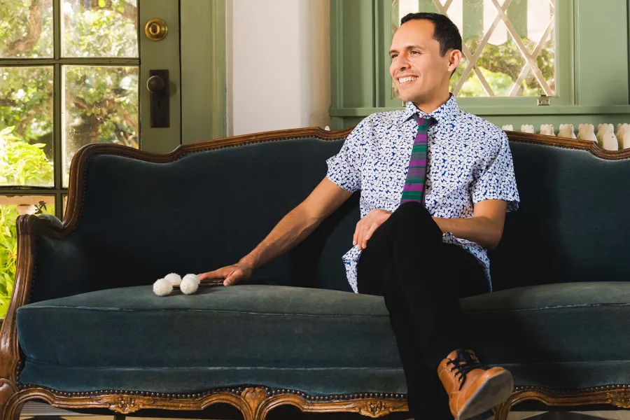 Ivan Trevino sitting on a couch with drum mallets