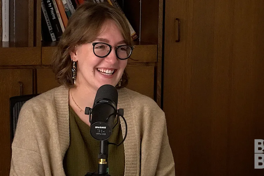 Chloe Yofan talking into a mic with a bookcase in the background