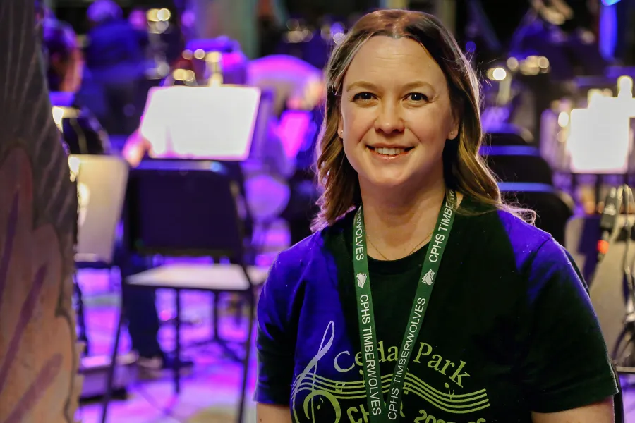 Lisa Holt looking at the camera with music stands in the background