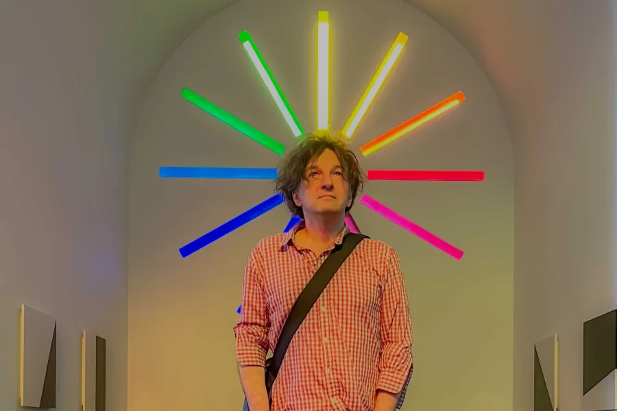 Vladimir Rannev standing in front of mondern art