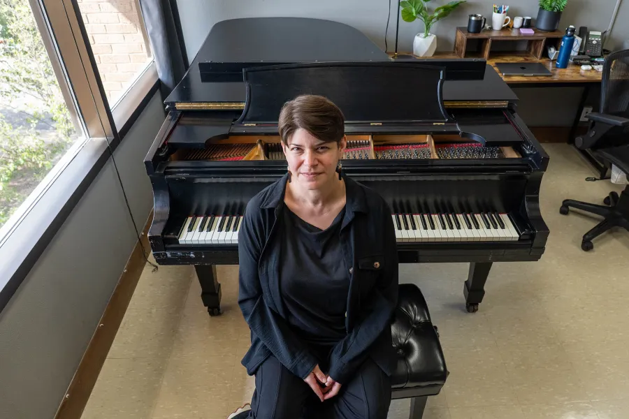 Alyssa Weinberg sitting in front of a piano in an office
